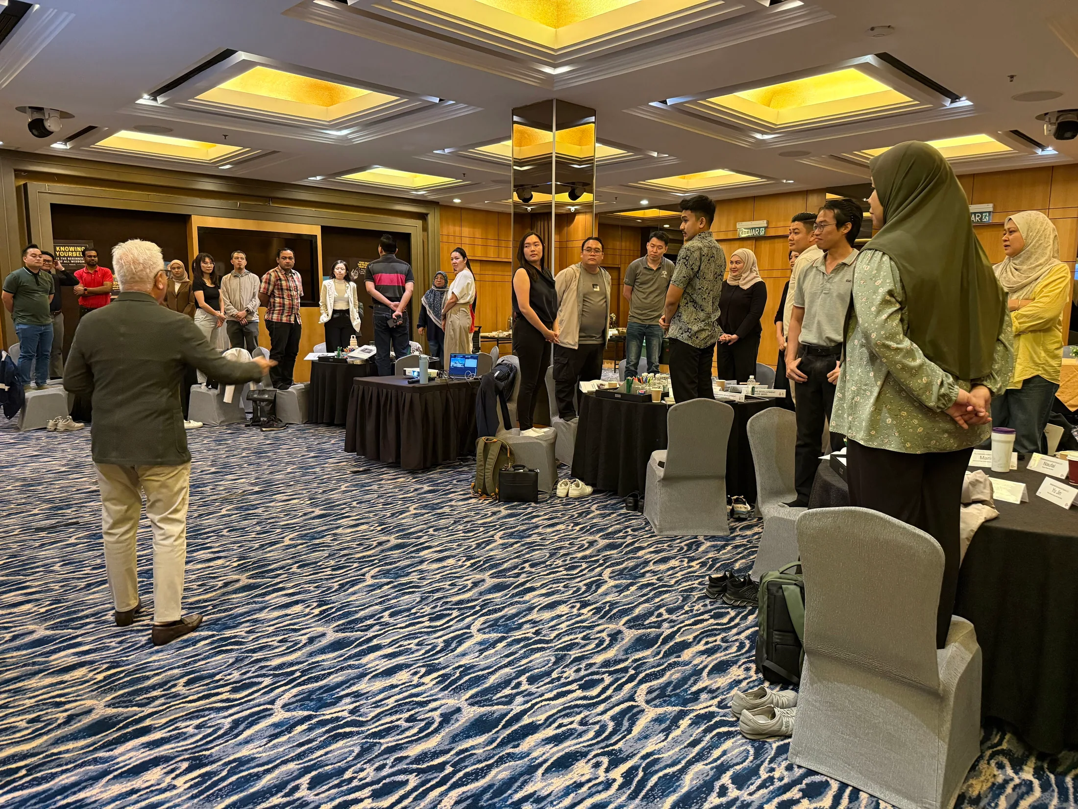 Facilitator speaking to a standing group of MDP participants